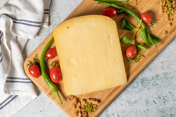 Old cheddar cheese. Traditional Old Sliced Turkish Kars Old Cheddar Cheese on a wooden serving board. Dairy products. Top view