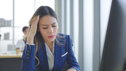 Close up exhausted face of employee woman stressed unhappy feeling sitting and working on desk at...