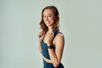 Three quarter length portrait of young caucasian woman in sportswear with towel around neck in studio