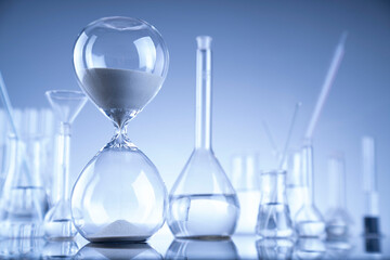 Laboratory investigations. Glass tubes and beakers on blue background.