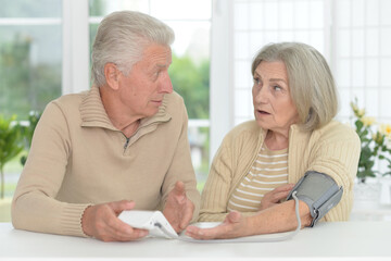 old couple measuring blood pressure together