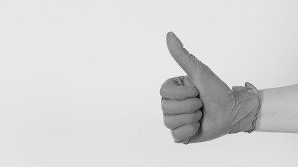 The hand is wearing a latex glove and do like hand sign on white background.