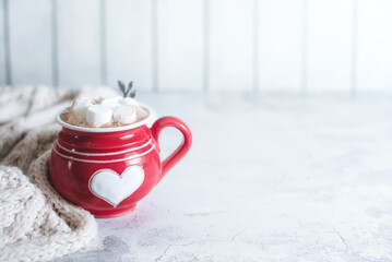 Cappuccino with marshmallow in mug on white table. Space for text.