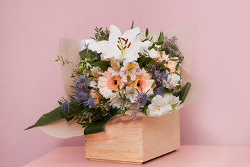bouquet with lily and gerbera in pink. mix of summer flowers for wedding in wooden box. getting ready for delivery