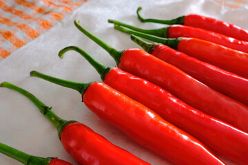 Close up of group of fresh red chillies, drying on kitchen towel, dish cloth after being washed. Selective focus; shallow depth of view