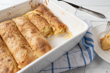 Filled pancake rolls with lemon quark filling in a white casserole dish
