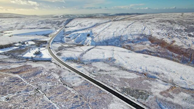 Cinematic cold English winter moorland aerial scene. Beautiful winter landscape in the mountains, with rocky cliffs and ridges. Saddleworth moor.