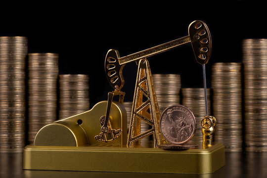Gold Oil Pump With A Coin Of 1 American Dollar Against The Background Of Stacked Gold Coins