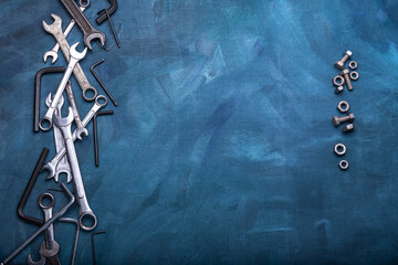 Wrenches and nuts on a blue background.