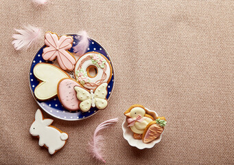 Easter trendy aesthetic background with copy space. Traditional glazing cookies and feathers. Easter food