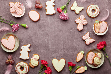 Easter aesthetic background with copy space top view, decorated cookies, aster flowers, feathers. Spring background.