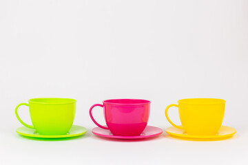 multi-colored plastic cups and plates on a white background kitchen set