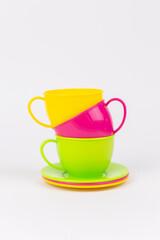 multi-colored plastic cups and plates on a white background kitchen set