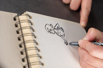 main d'un femme dessinant un personnage sur un blox à dessin avec spirales - obrazy, fototapety, plakaty