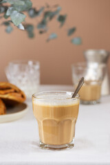 Breakfast coffee latte in a glass with cinnamon buns on the table, rustic style.