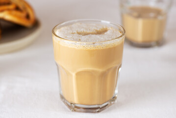 Morning coffee latte in a glass with cinnamon buns on the table, rustic style.