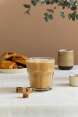 Breakfast concept coffee latte in a glass with cinnamon buns on the table, rustic style.