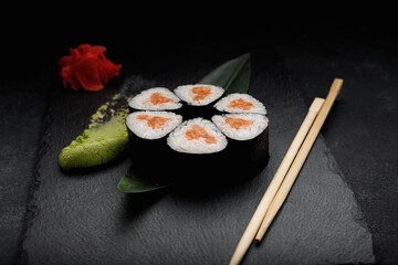sushi rolls with salmon. on a black stone