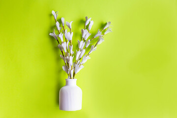 White vase with flowers on neon green background isolated 