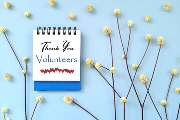 Thank You Volunteers message on blue notepad card with minimalist natural design.