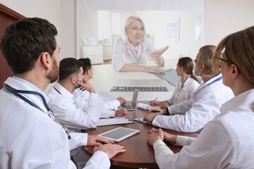 Lecture with online participant. Doctors in meeting room. Using projector for videoconference