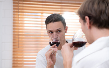 LGBT Young couple celebrate the day of love between each other with fine wine in the kitchen of the house