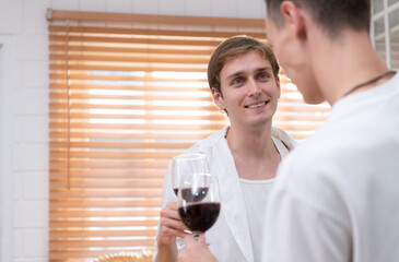 LGBT Young couple celebrate the day of love between each other with fine wine in the kitchen of the house