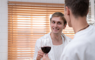 LGBT Young couple celebrate the day of love between each other with fine wine in the kitchen of the house