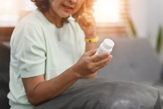 Photo of mature woman woman taking daily medicine. Elderly healthcare, pharmaceutical concept