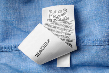 White clothing labels on light blue garment, top view