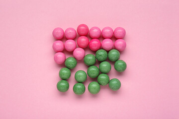 Many bright chewy gumballs on pink background, flat lay