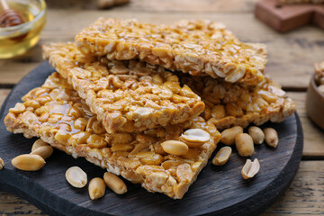 Delicious peanut kozinaki bars on wooden table, closeup