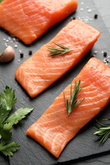 Fresh raw salmon and ingredients for marinade on black table