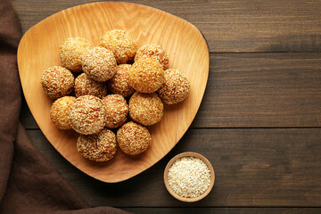 Delicious sesame balls on wooden table, flat lay. Space for text