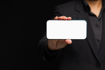 Hand holding a white blank screen smartphone against a black background