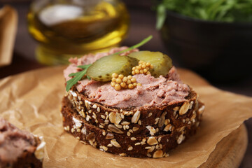 Delicious liverwurst sandwich with pickled cucumber and mustard on table, closeup