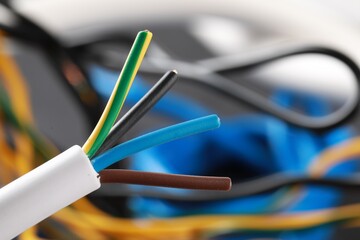 One new colorful electrical wire on blurred background, closeup view