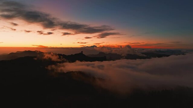 Magical sunset above the clouds with Teide volcano on the horizon. Sunset cinematic view from the top of Gran Canaria Island Pico de las Nieves point.