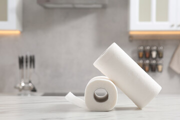 Rolls of paper towels on white marble table in kitchen. Space for text