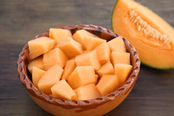 Cut delicious ripe melon on wooden table, closeup