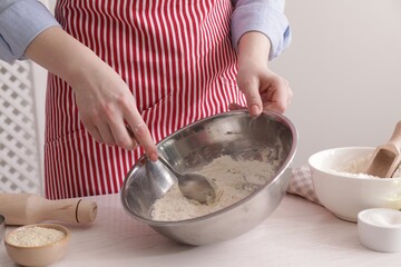 Woman making traditional grissini at white wooden table indoors, closeup
