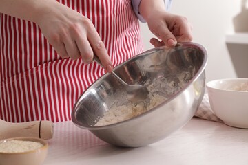 Woman making traditional grissini at white wooden table indoors, closeup