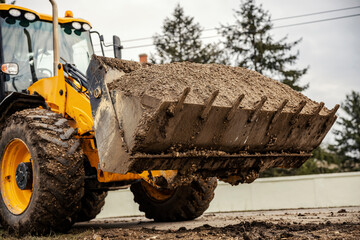 Cropped picture of a bulldozer with gravel on construction site.