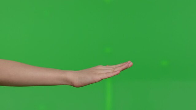 Close up side view of Child's hand laying on something imaginary virtual and invisible on green screen chroma key background..