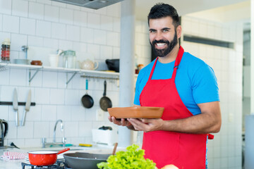 Handsome mature adult father cooking healthy food for children at kitchen