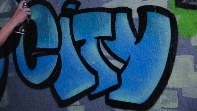 An image of the word city painted with spray paint on a wall to form graffiti.