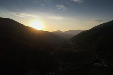 Aerial view during a sunset over Prahova Valley and DN1 national road from Romania at the bottom of Bucegi Mountains.