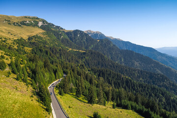 Aerial view of Bucegi Mountains and Transbucegi waving road on top of them. Landmarks of Romania,...