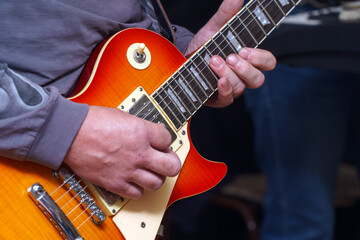 The guitarist plays on guitar. Hands of a Guitar player playing the guitar. Selective focus.