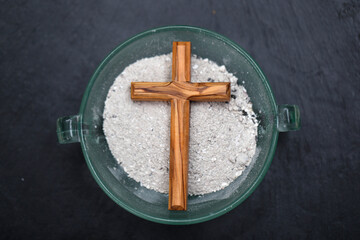 Ashes and wooden christian cross. Ash Wednesday celebration. Lent season.